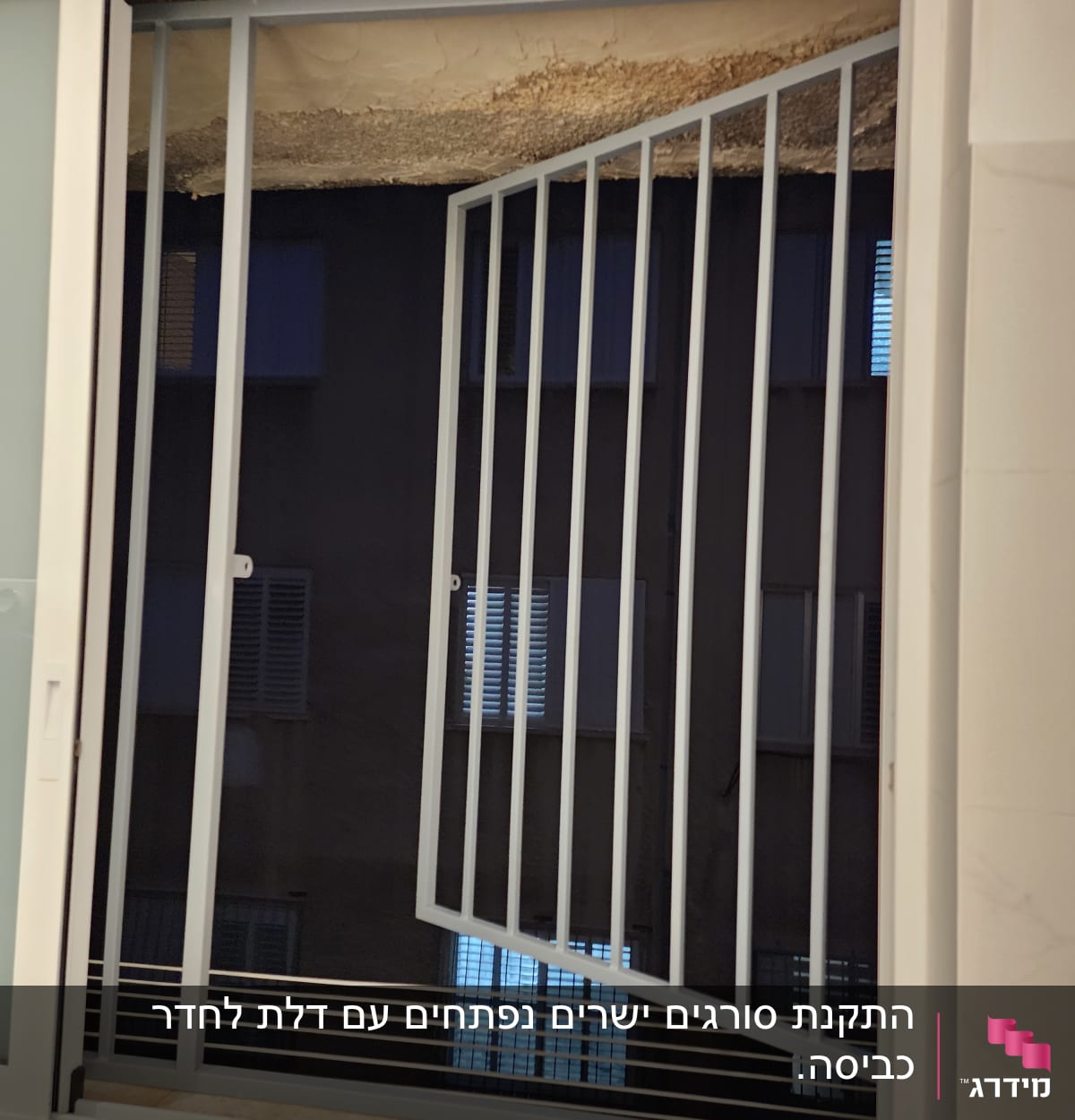 סורג מתכת פתוח בחלון עם מסגרת לבנה